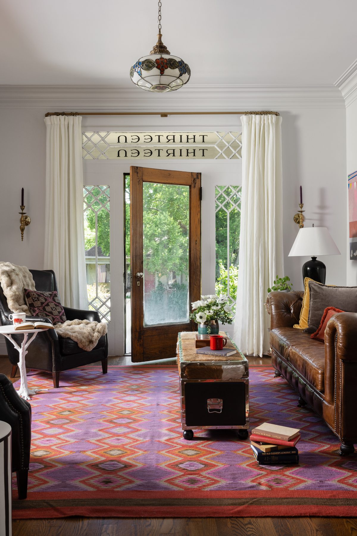 An entryway furnished with preloved leather seating and a vintage rug